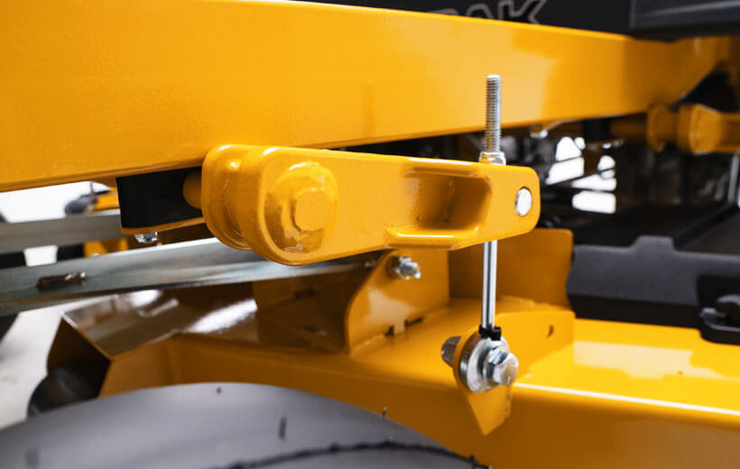 Close-up of a yellow mechanical component, likely from a lawn mower or similar equipment.