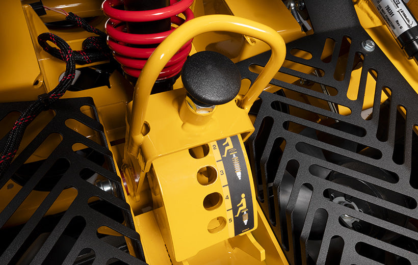 Close-up of a yellow mechanical component with black and red parts in the background