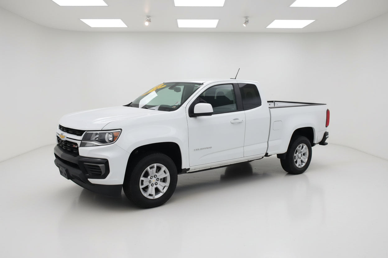 White pickup truck parked in front of a building with a gray sky.