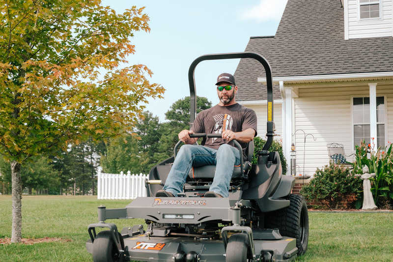 Man operating a riding lawn mower in a residential yard