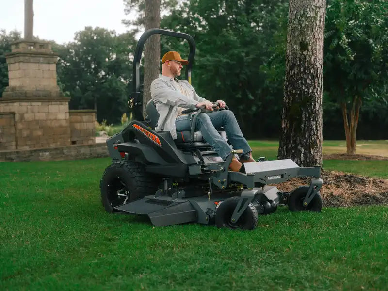 Person operating a zero-turn lawn mower in a park-like setting