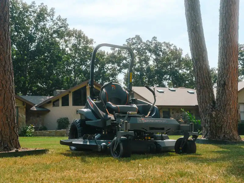 Zero-turn lawn mower on a grassy area with trees and houses in the background