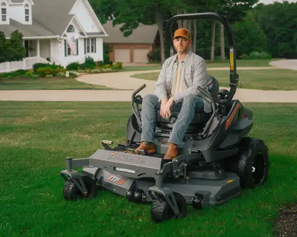 Man sitting on a riding lawn mower in a suburban neighborhood