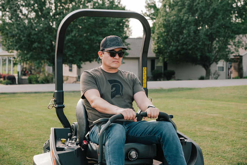 Man operating a lawn mower in a residential area