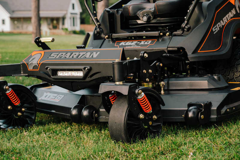 Spartan lawn mower on a grassy area with a house in the background
