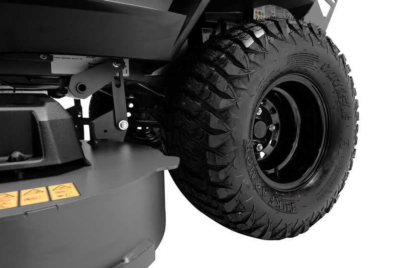 Close-up of a large black tire with treads on a white background