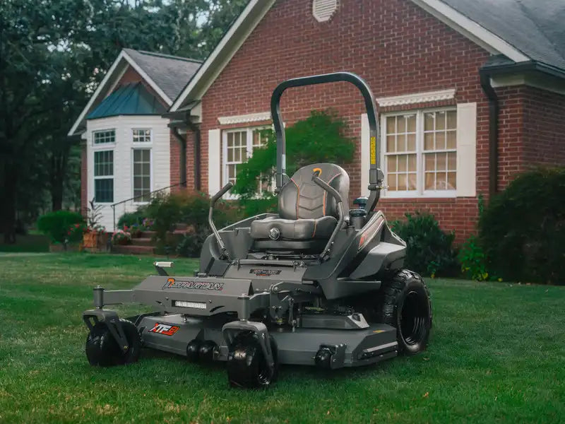 Zero-turn lawn mower on a grassy lawn in front of a house