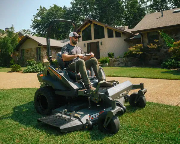 Man operating a riding lawn mower in a residential yard