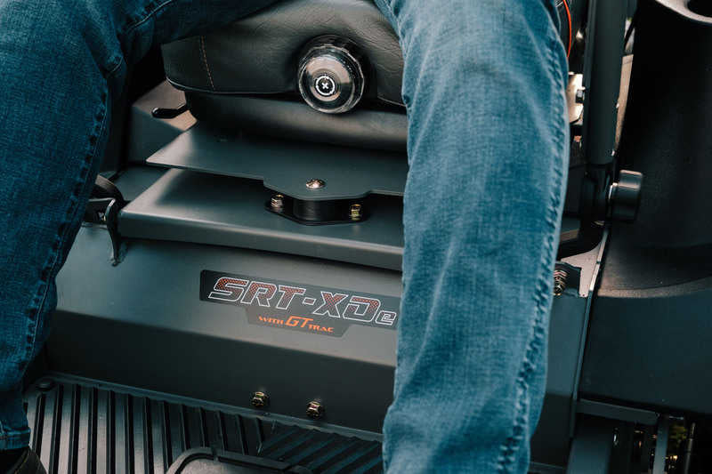 Person sitting on a SRT-XD8 vehicle seat with visible branding.