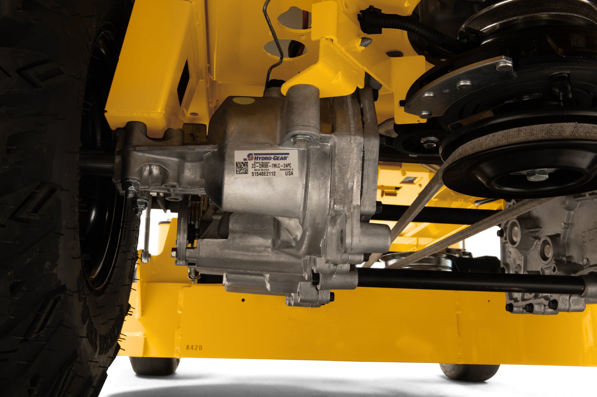 Close-up of a yellow mower's undercarriage with mechanical components.