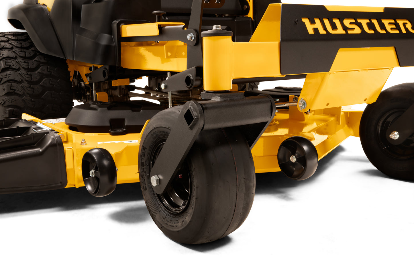 Close-up of a yellow and black Hustler lawn mower on a white background