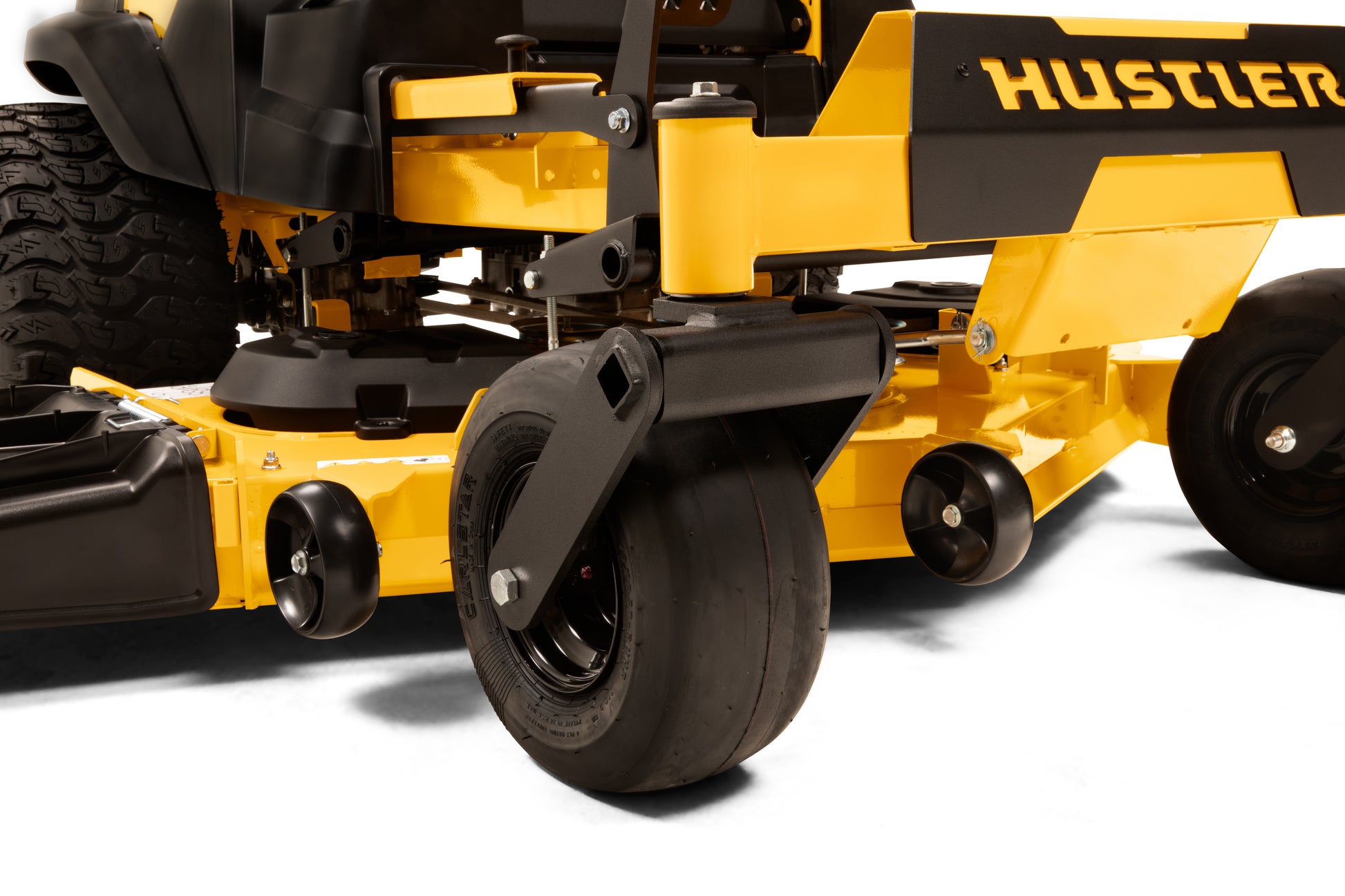 Close-up of a yellow and black Hustler lawn mower on a white background