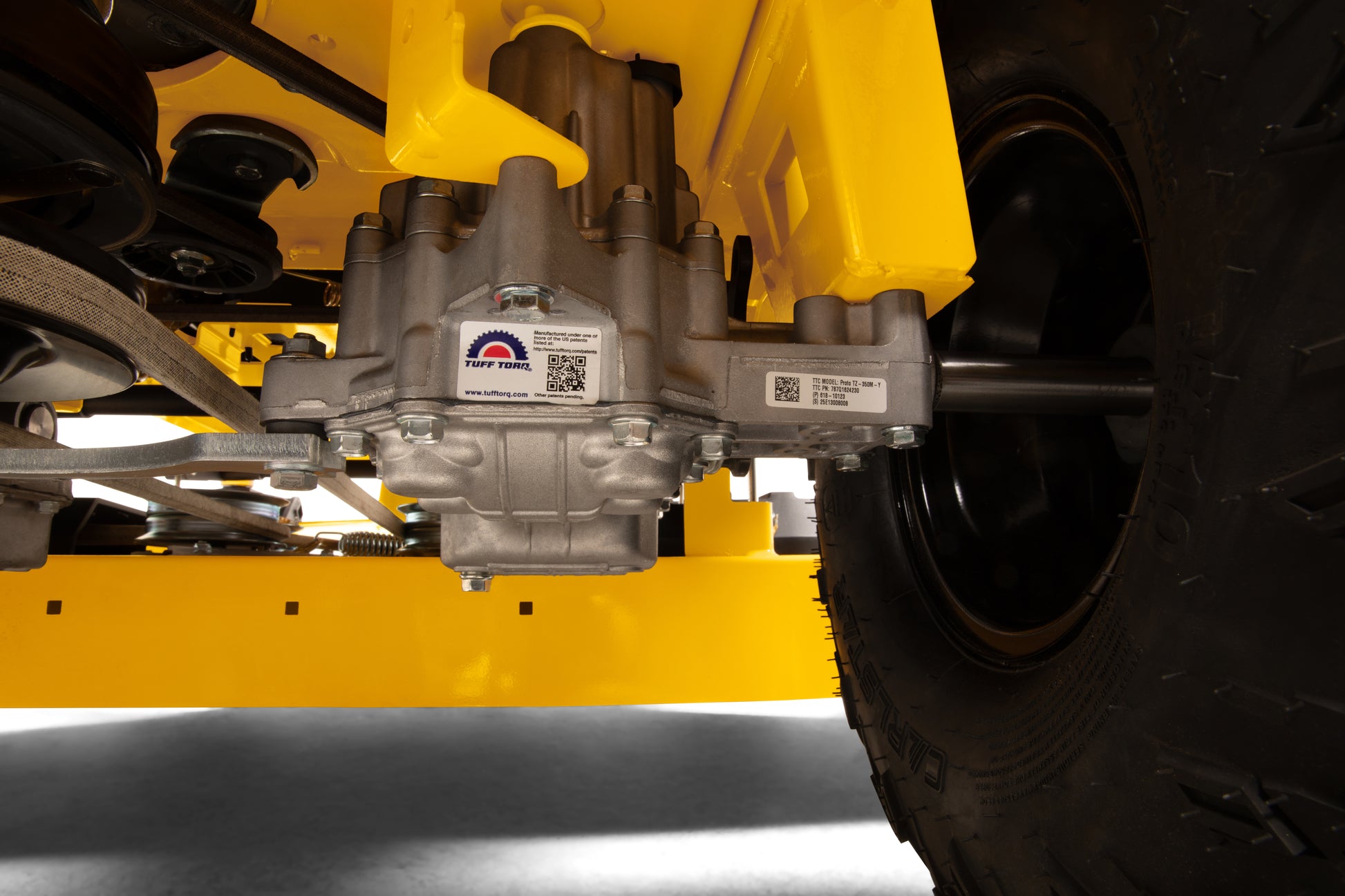 Close-up of a vehicle's undercarriage with a yellow frame and mechanical components.
