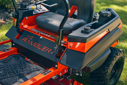 Close-up of a red and black riding lawn mower with 'KZ Rambler' branding on a grassy background.