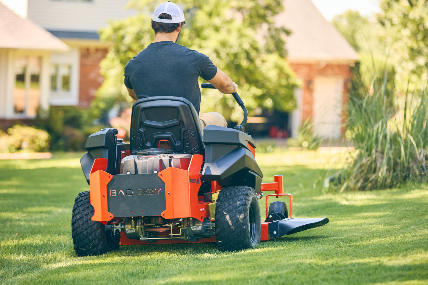 Person operating a riding lawn mower in a residential yard