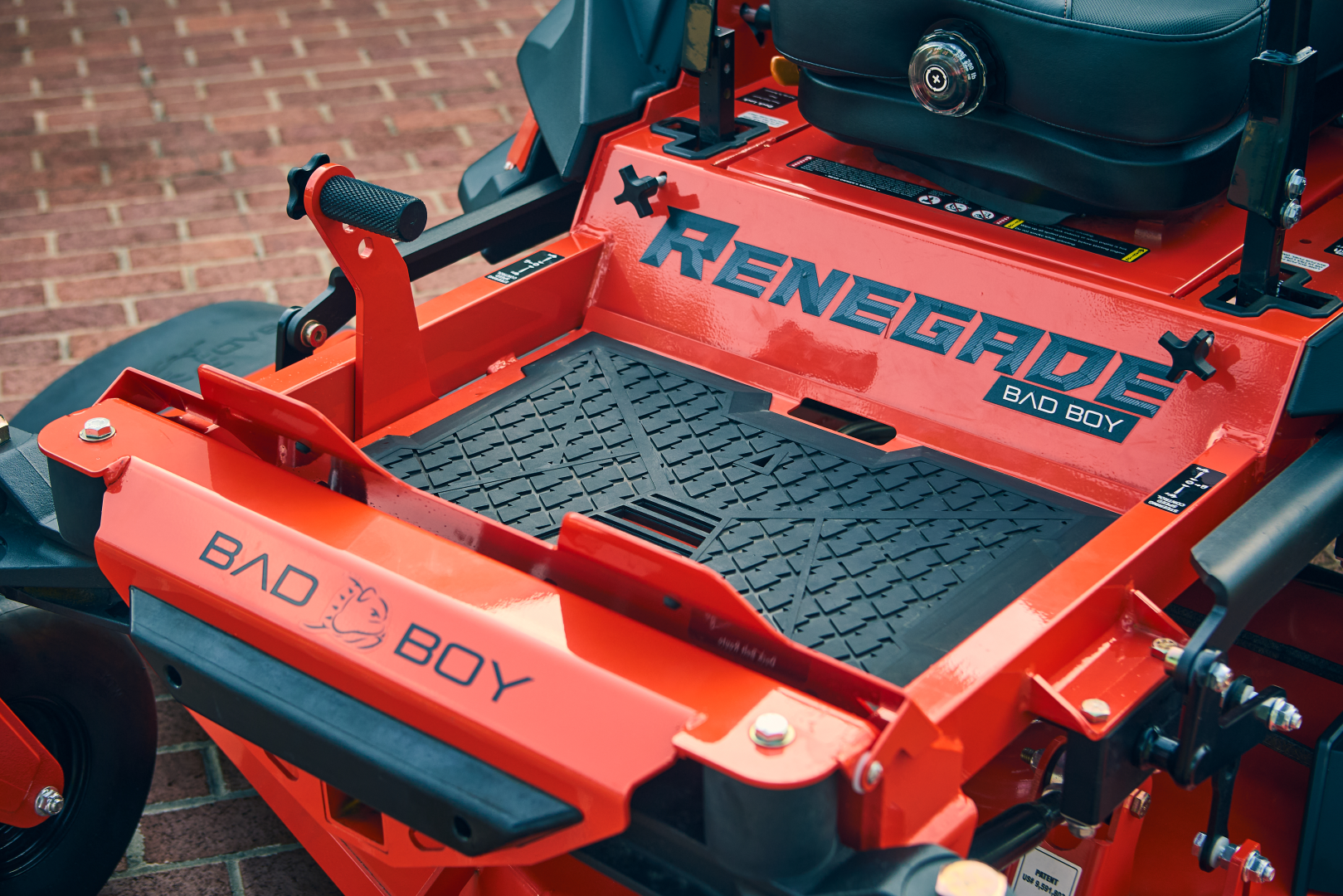 Red lawn mower with 'Renegade' and 'Bad Boy' branding on a brick background