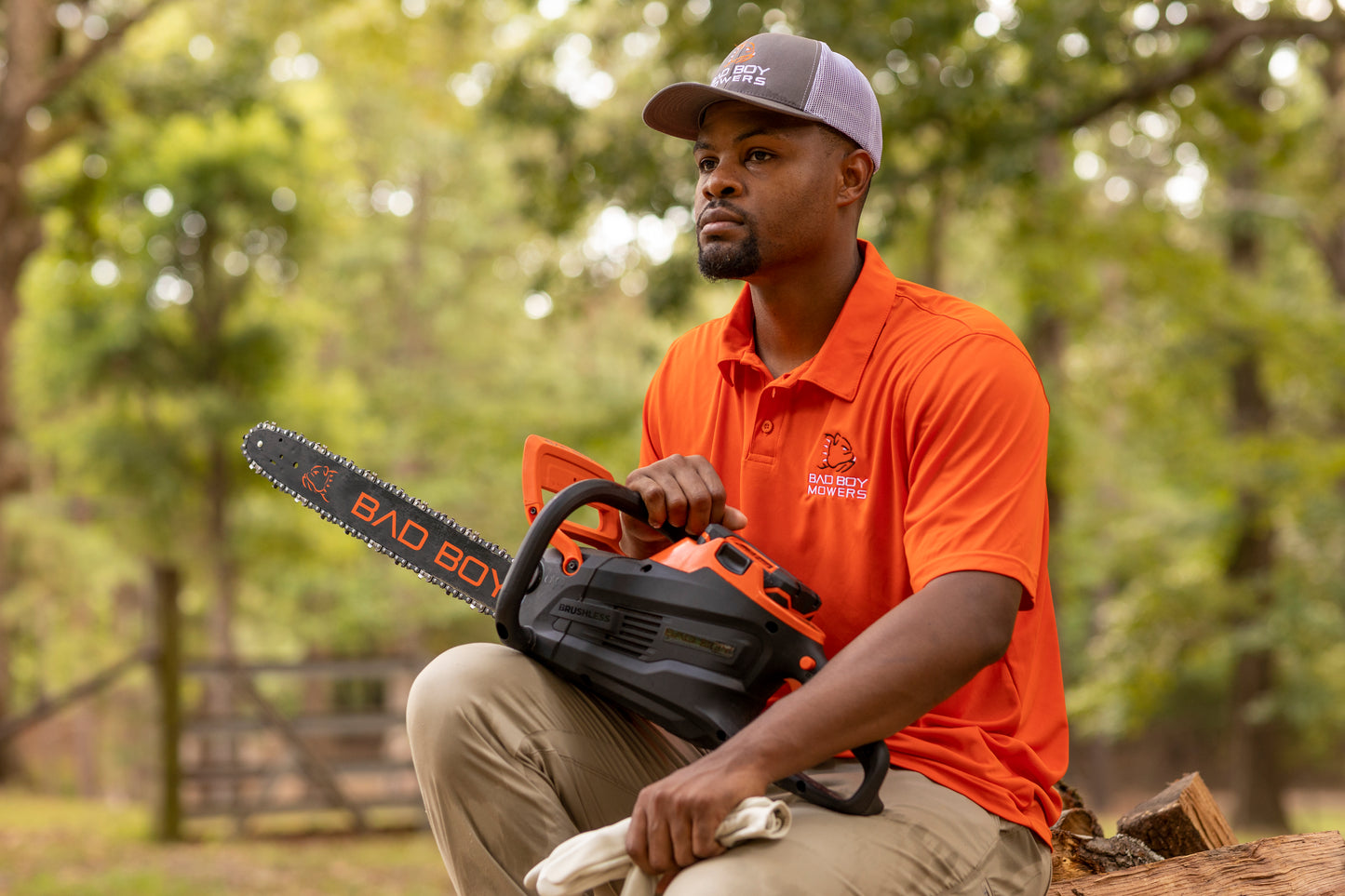 Person holding a chainsaw with a blurred natural background