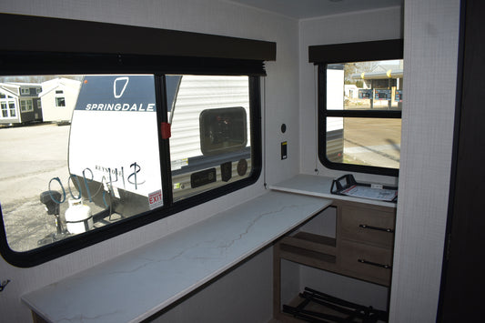 Interior of a vehicle showing a counter with a window view of a Springdale trailer.