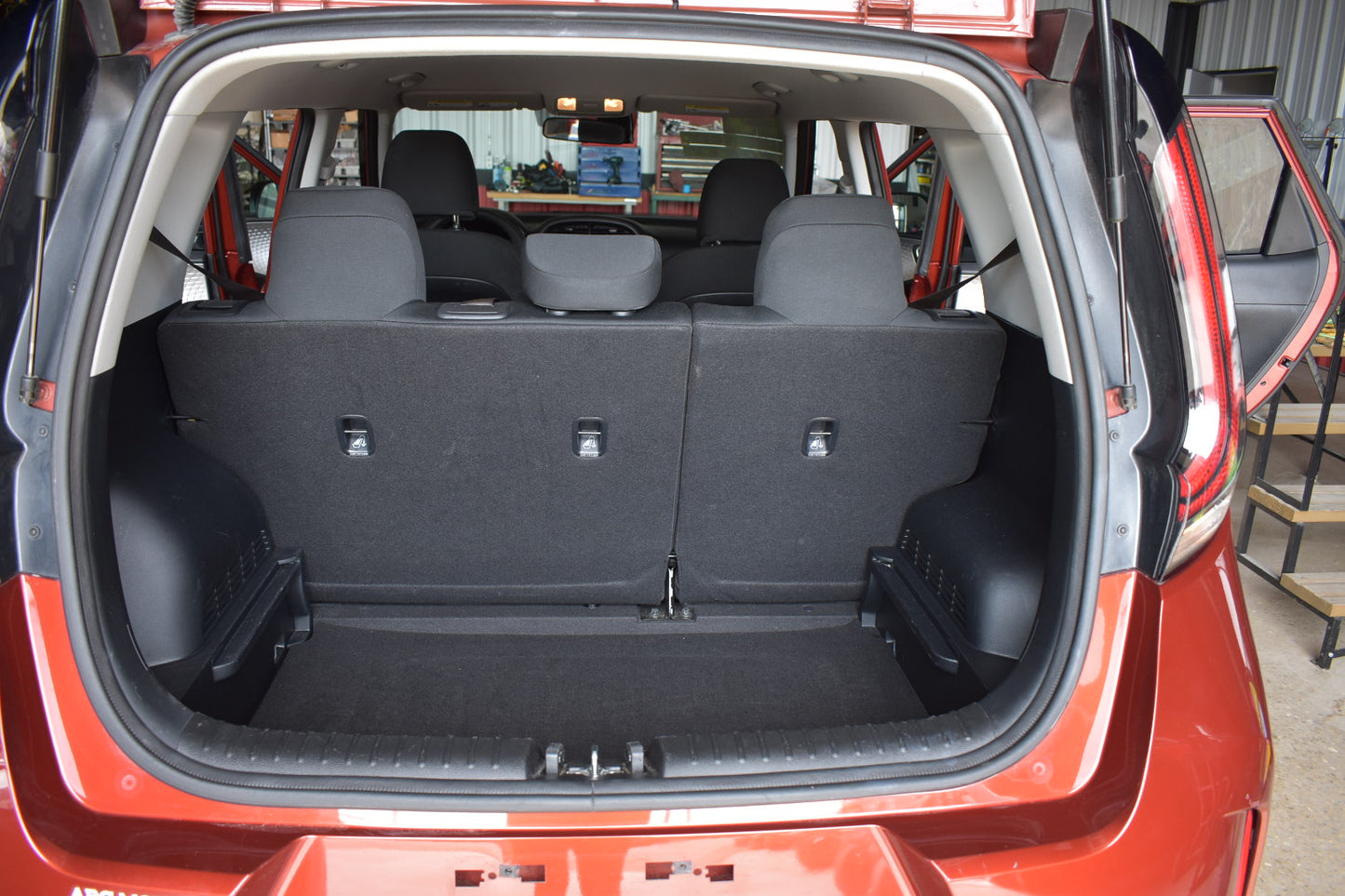 Open car trunk with black interior and visible floor, showing a clear view of the cargo area.