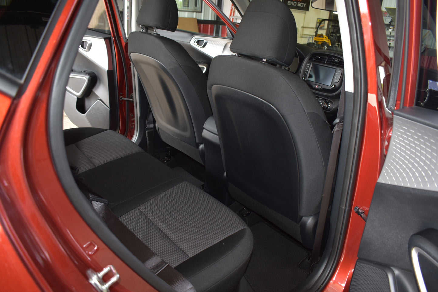Interior of a red car with open door showing black seats