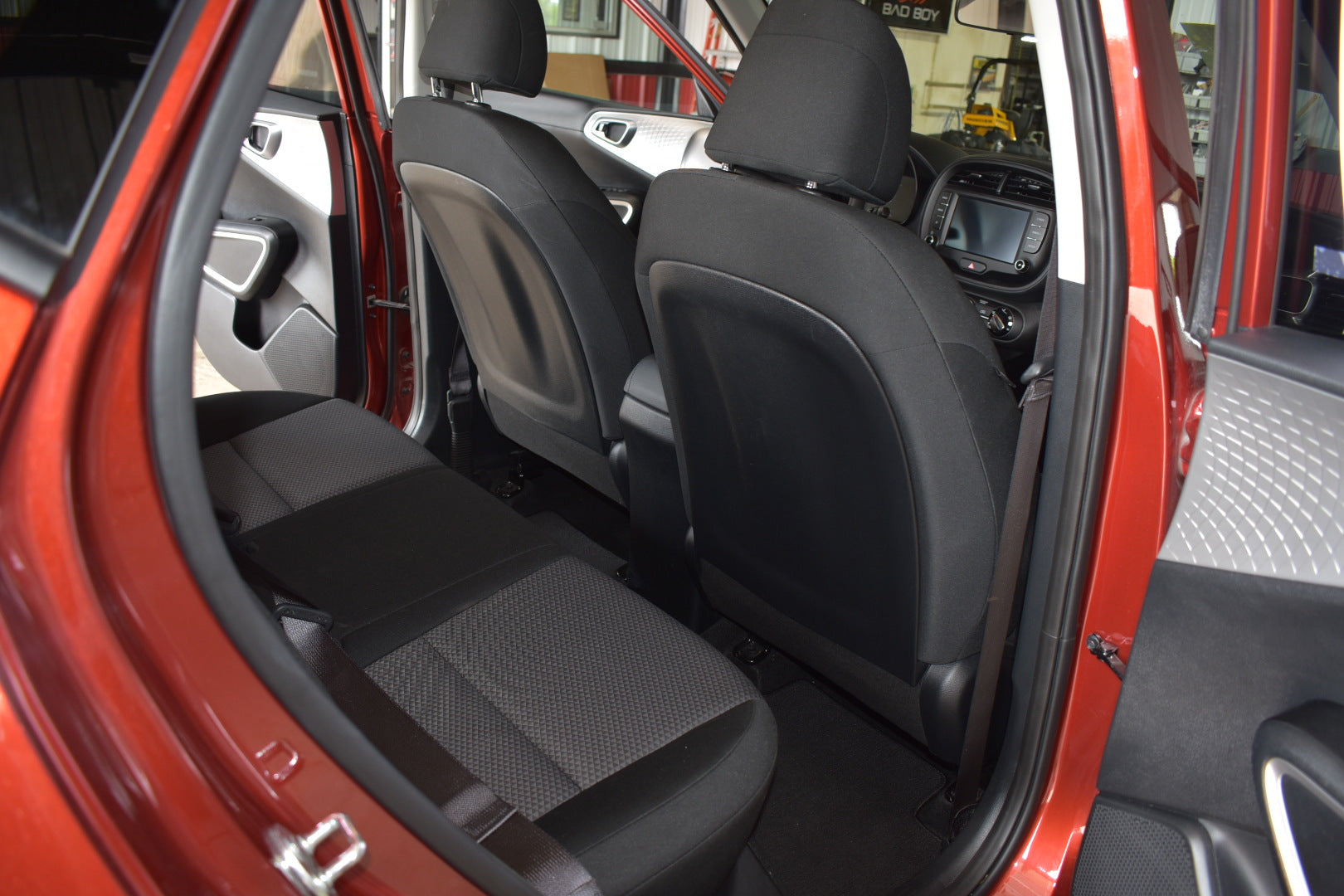 Interior of a red car with open door showing black seats