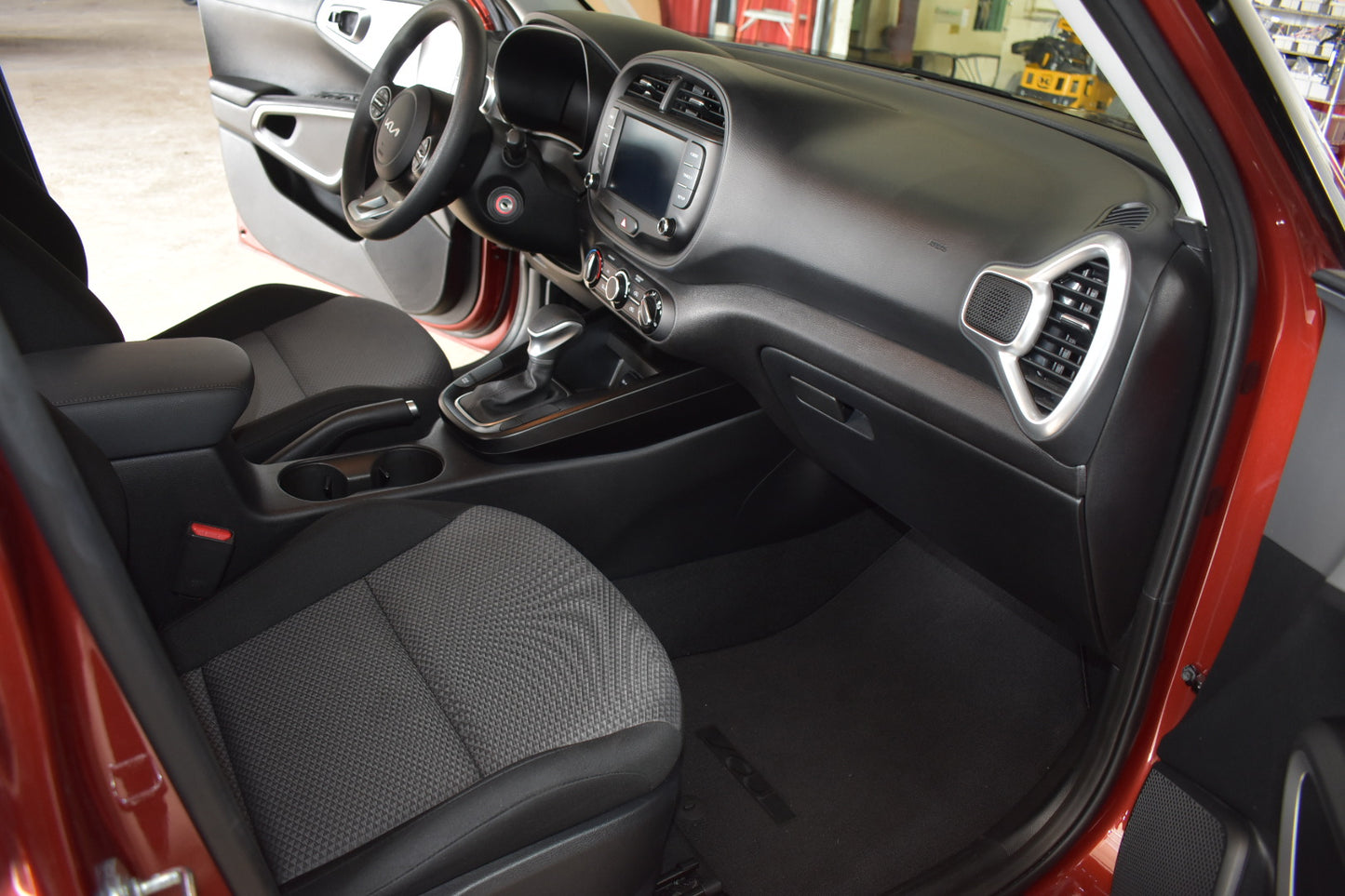 Interior of a red car with black seats and dashboard.