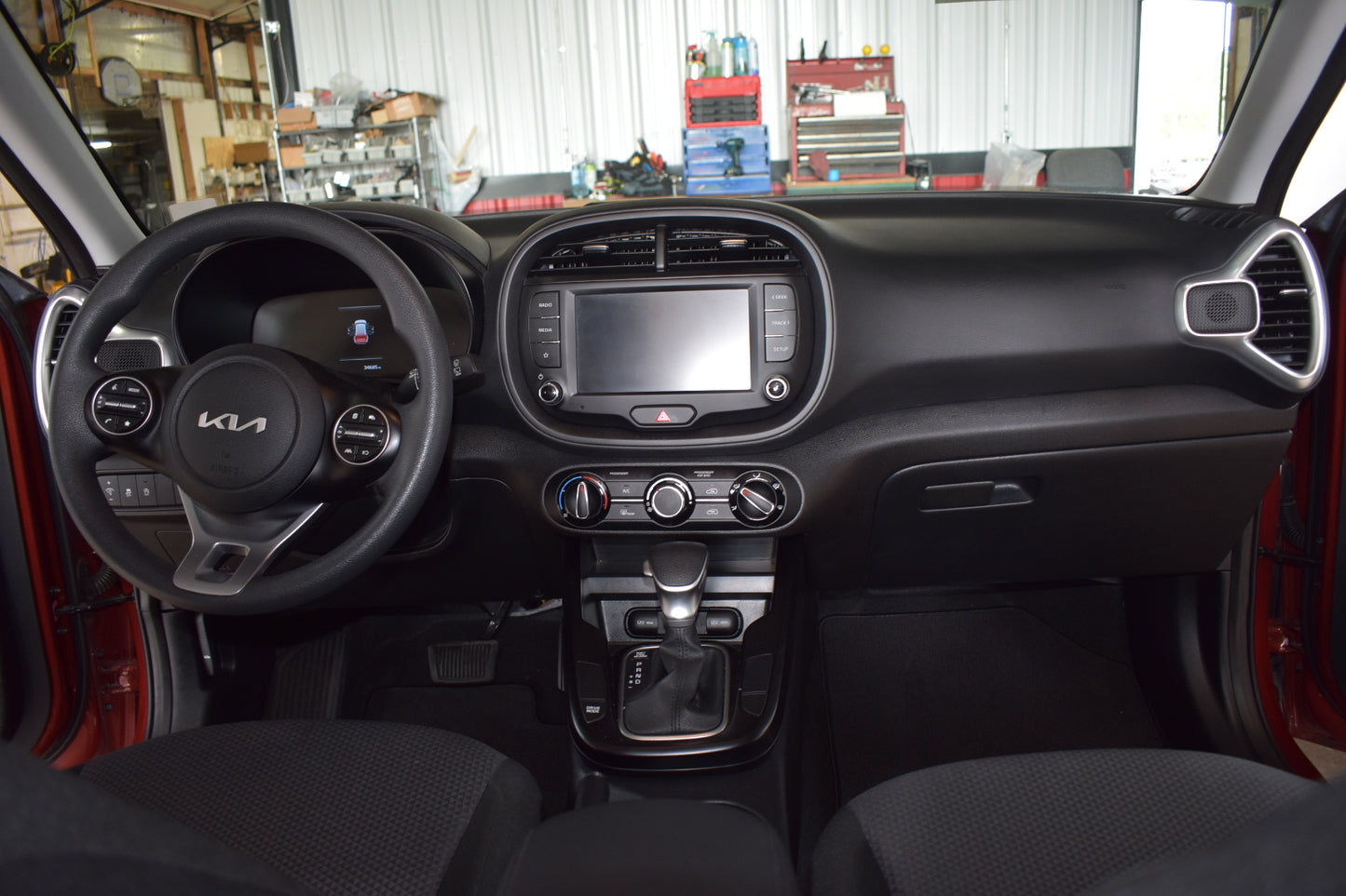 Car interior of a Kia vehicle with dashboard and steering wheel visible.