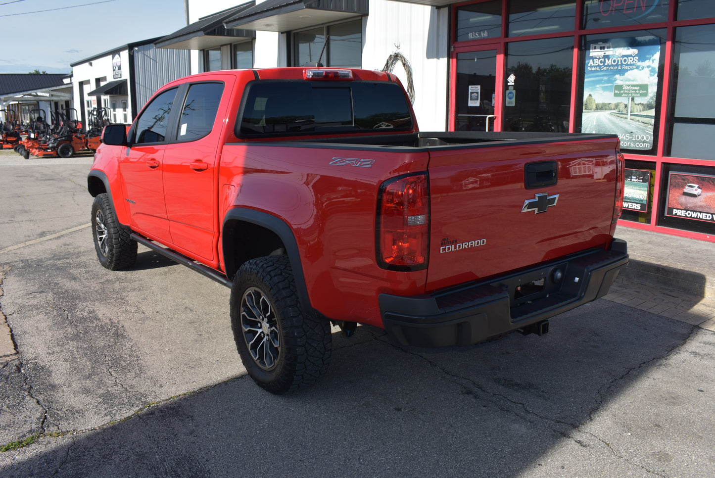 Red Chevrolet truck parked in front of a dealership building