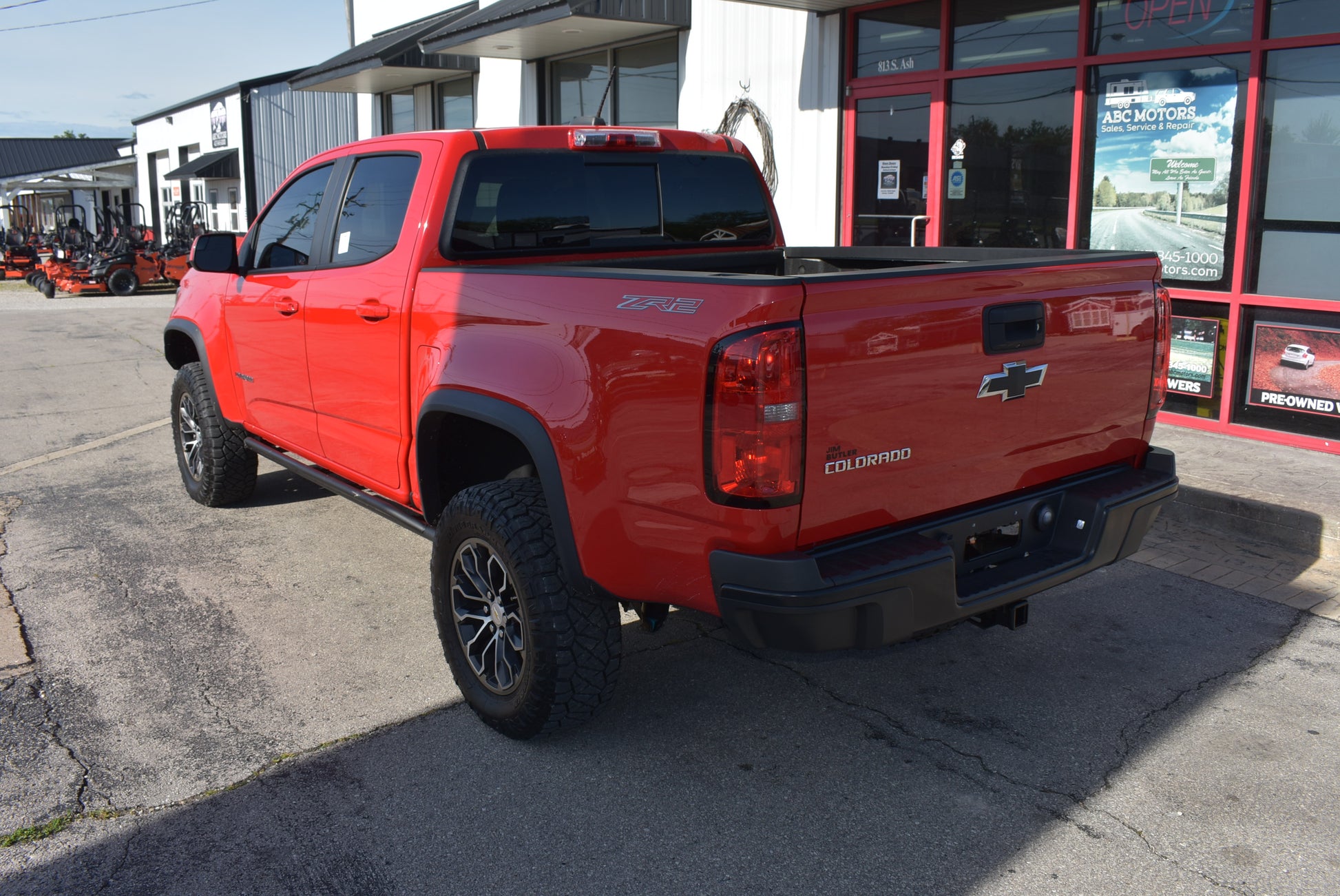 Red Chevrolet truck parked in front of a dealership building