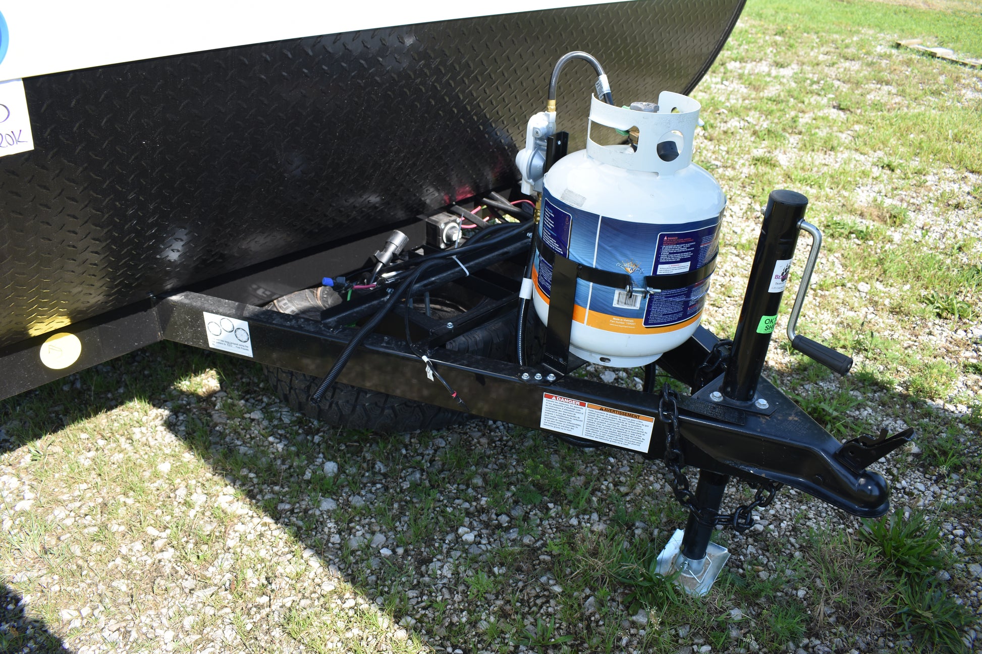 Propane tank attached to a trailer on a grassy area