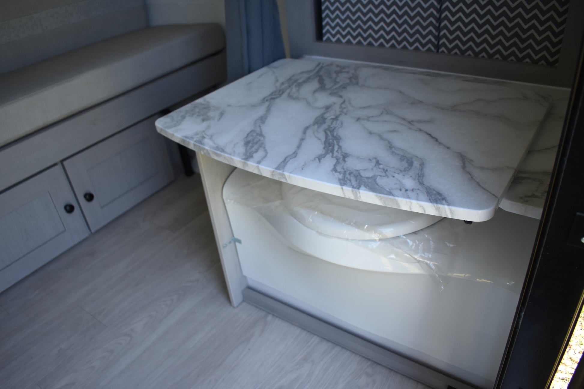 Marble-patterned table with storage underneath in a compact living space.