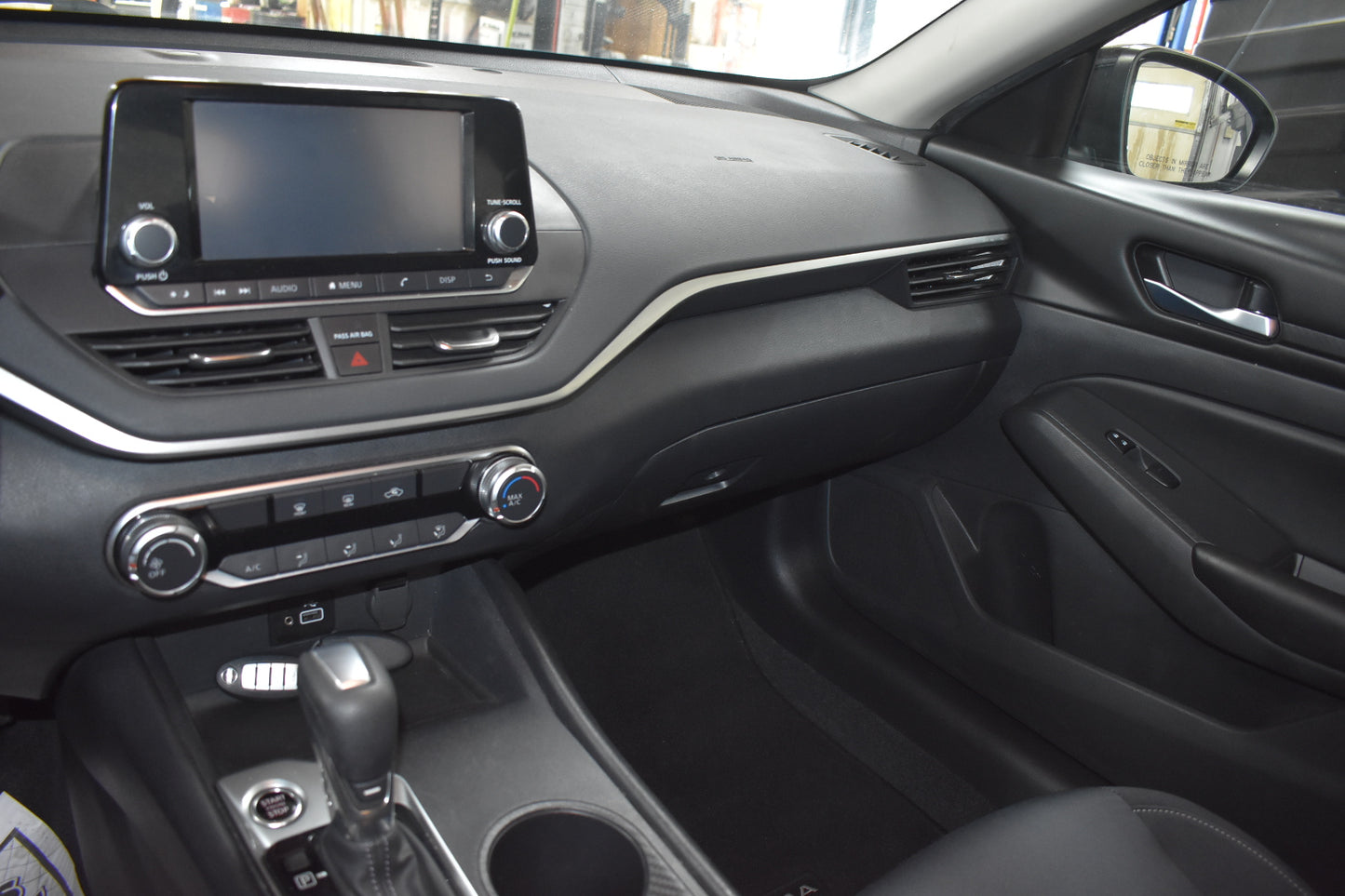 Car interior with dashboard, steering wheel, and center console.