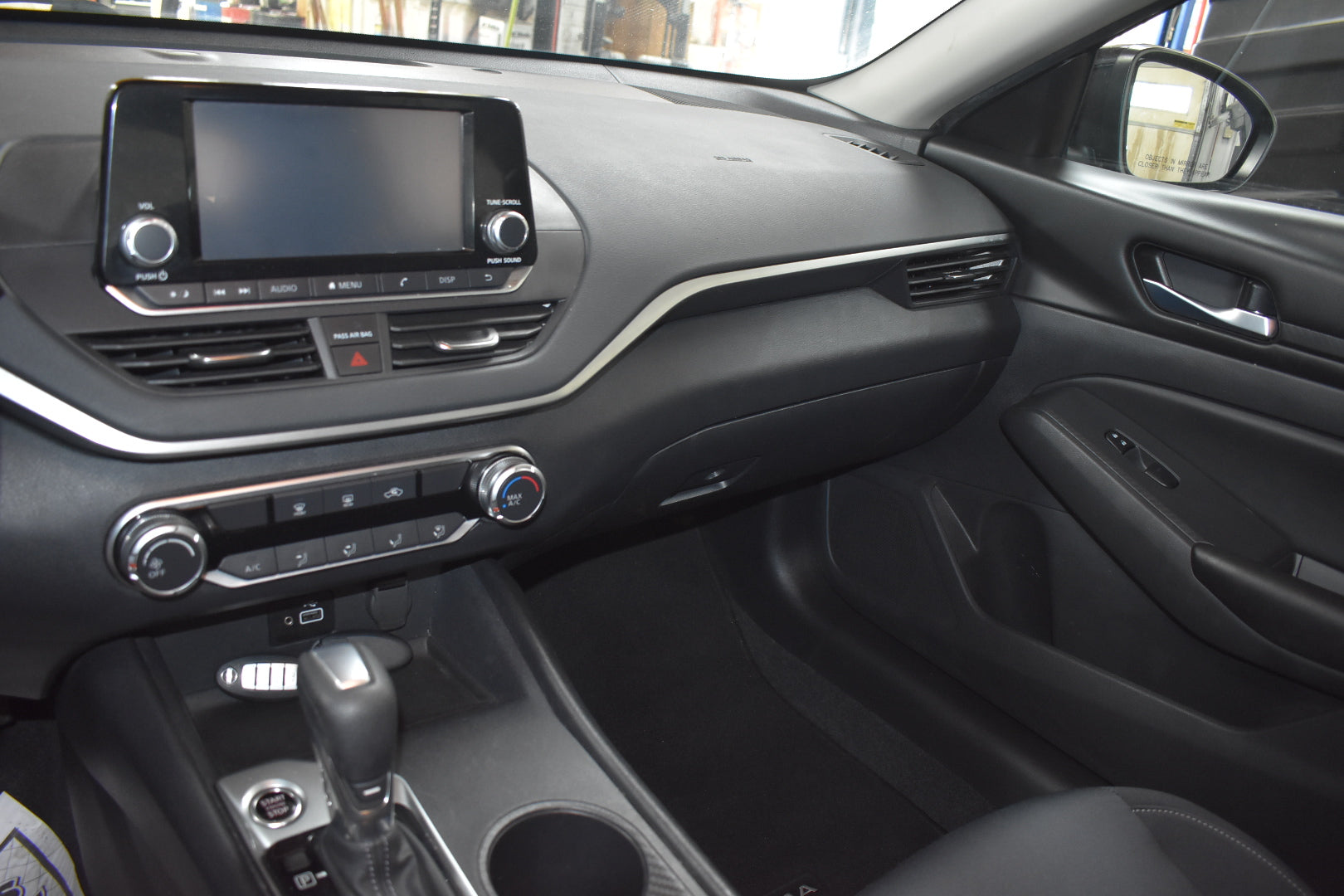 Car interior with dashboard, steering wheel, and center console.