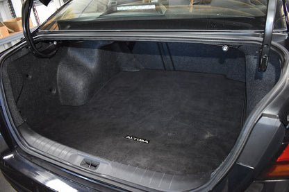 Car trunk with a black cargo mat featuring the 'Altim' brand name.