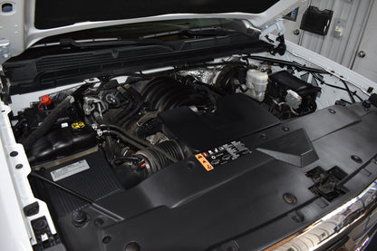 Open hood of a vehicle showing the engine compartment.
