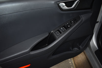 Close-up of a car door panel with controls and handle
