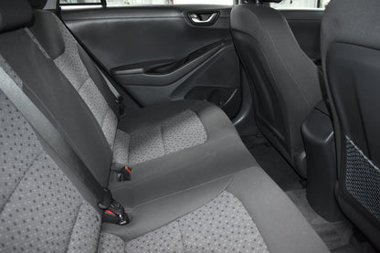 Gray car interior with visible seat belts and door panel.
