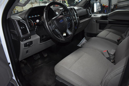 Car interior with steering wheel and dashboard in a workshop setting