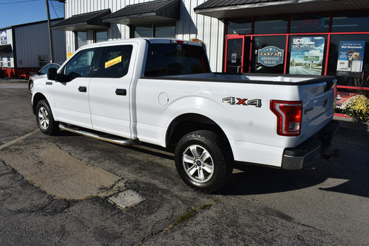 White pickup truck with '4x4' designation parked in front of a building.