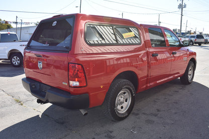 Red pickup truck with a canopy in an outdoor setting