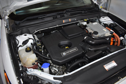 Car engine compartment with 'Hybrid' label open hood