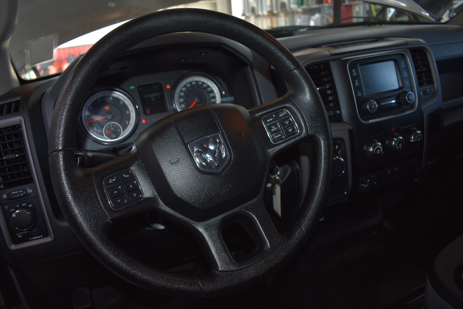 Steering wheel and dashboard of a vehicle with a visible brand logo.