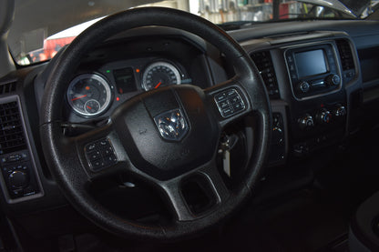 Steering wheel and dashboard of a vehicle with a visible brand logo.