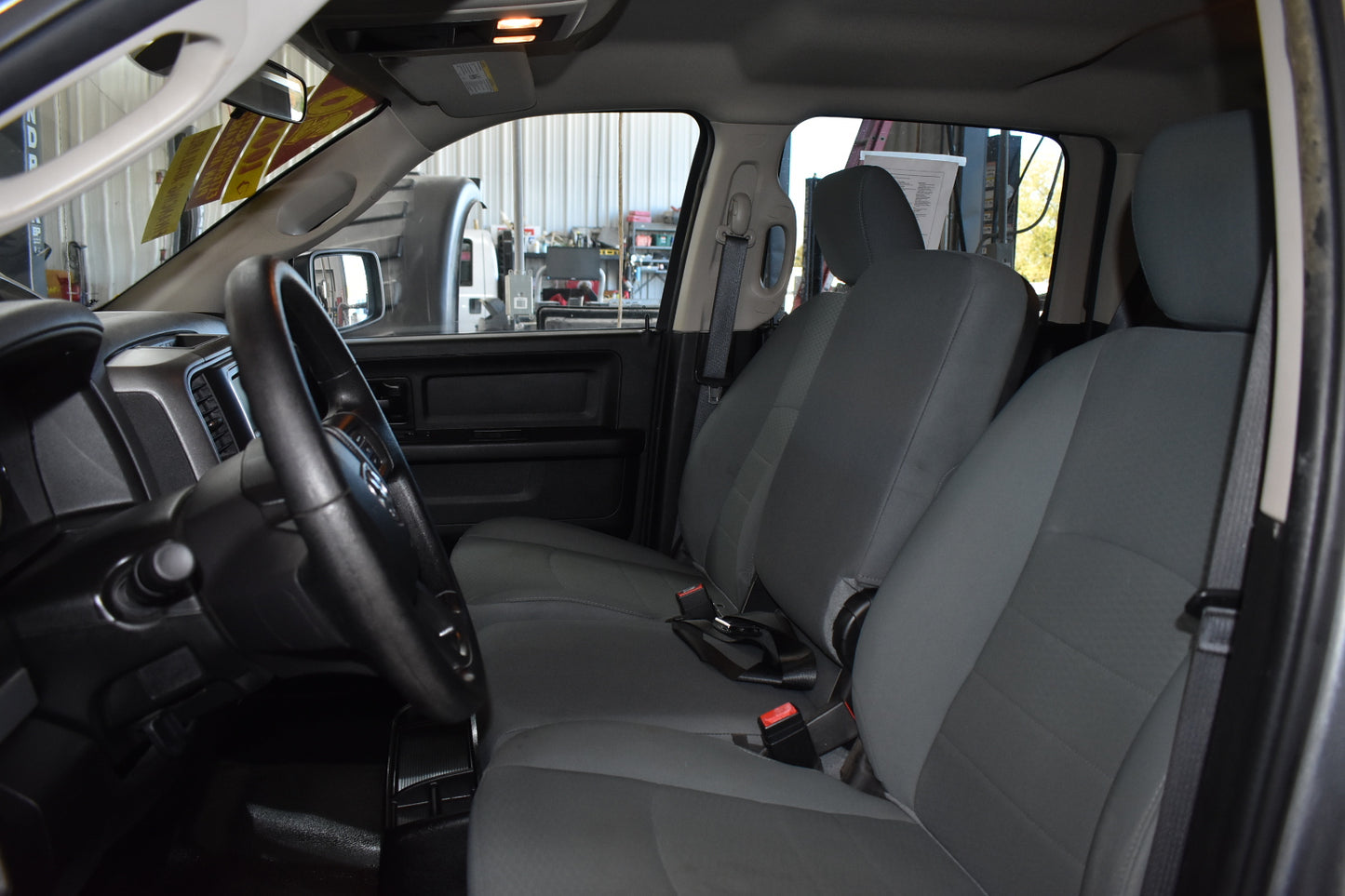 Interior of a vehicle with gray seats and dashboard.