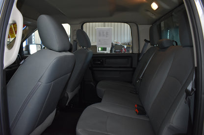Interior of a vehicle with gray seats and a view of the outside through the windows.