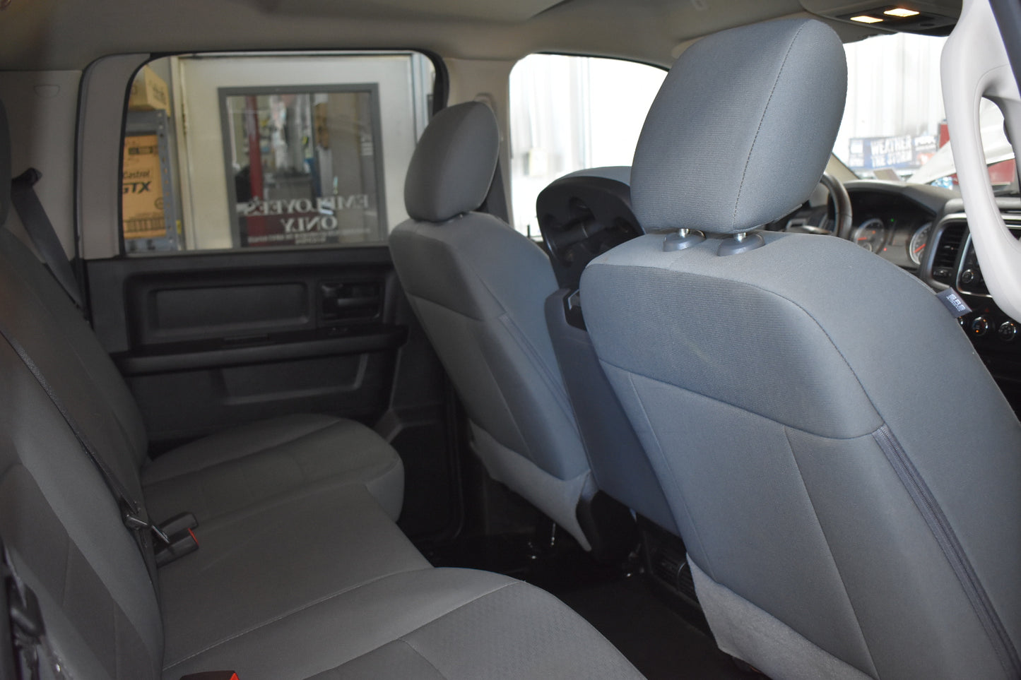 Gray interior of a vehicle with headrests and a magazine on the backrest.