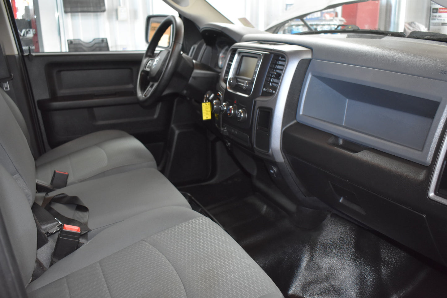 Interior of a vehicle with gray seats and dashboard.