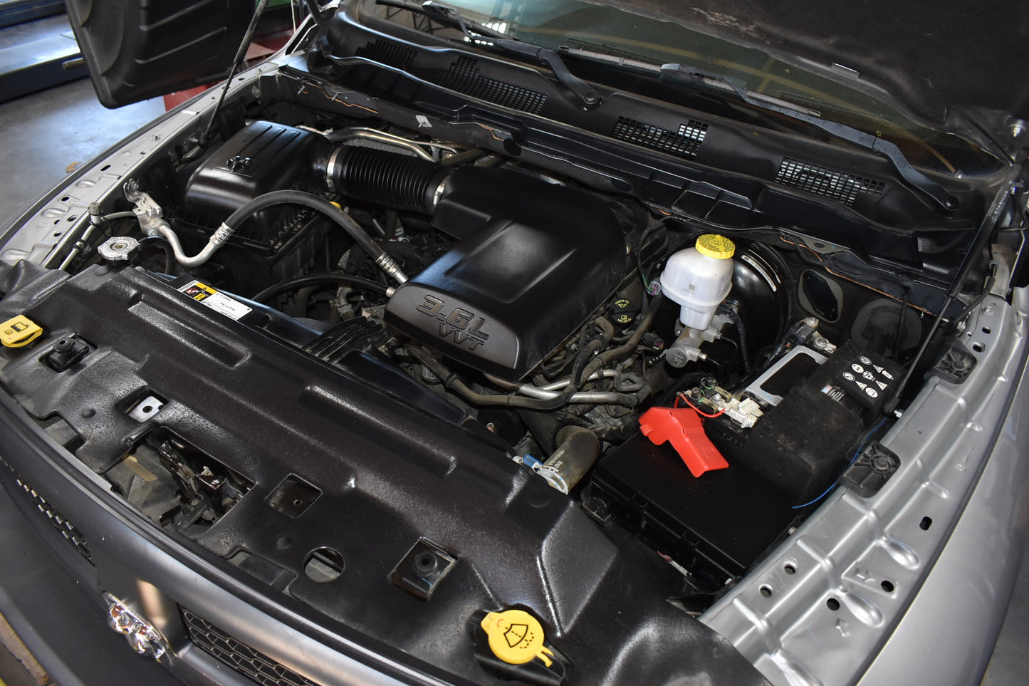 Car engine compartment with various components visible