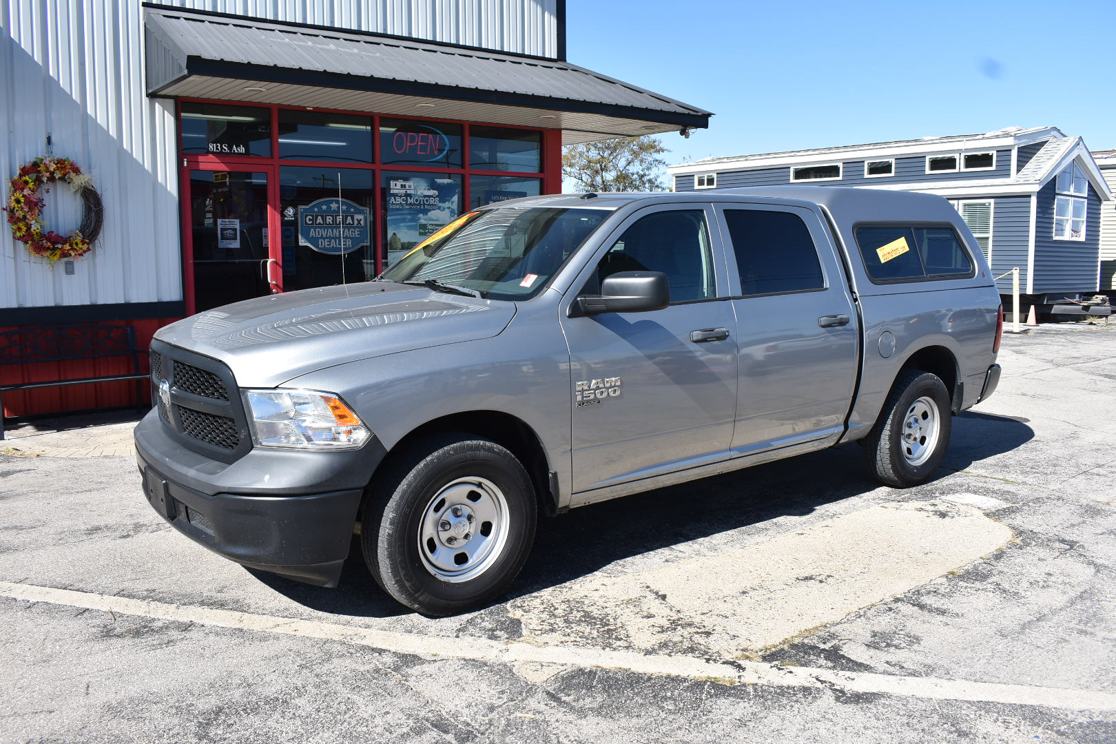 Gray pickup truck parked in front of a building with a wreath on the door.