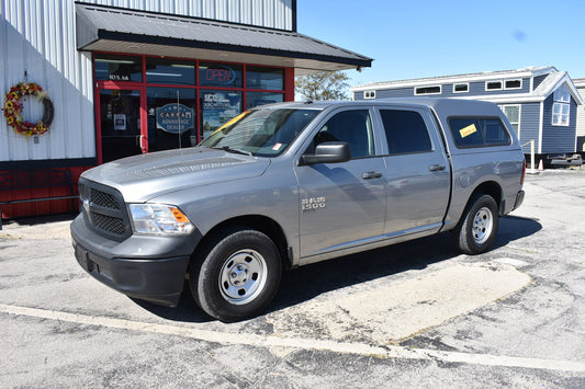 Gray pickup truck parked in front of a building with a wreath on the door.